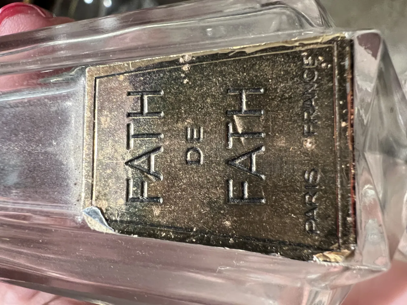 Frasco de perfume antiguo de Fath en un entorno neutro.