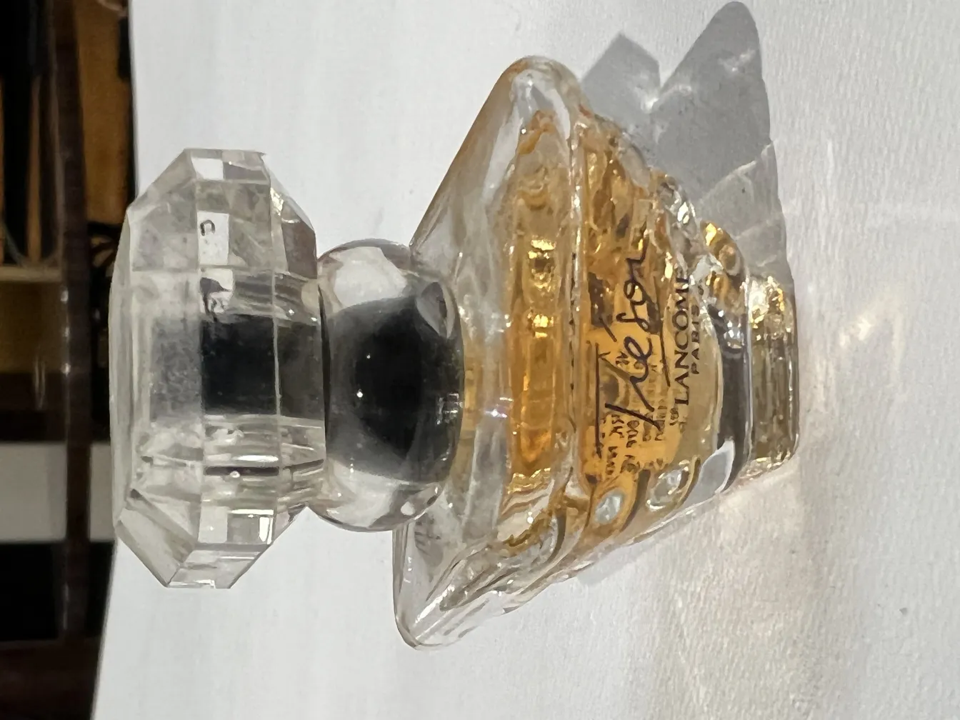 Flacone di profumo antico con coperchio in vetro, fronte decorativo.