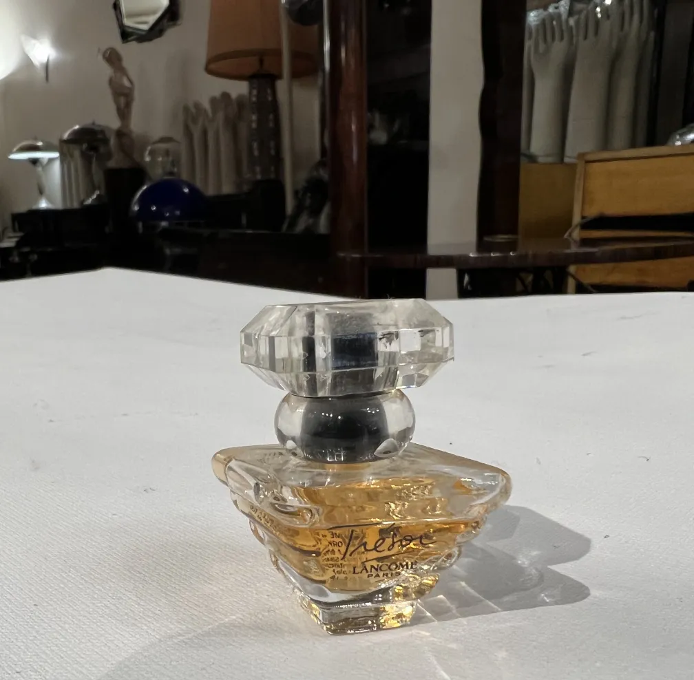 flacon de parfum ancien avec couvercle en verre dans un cadre élégant