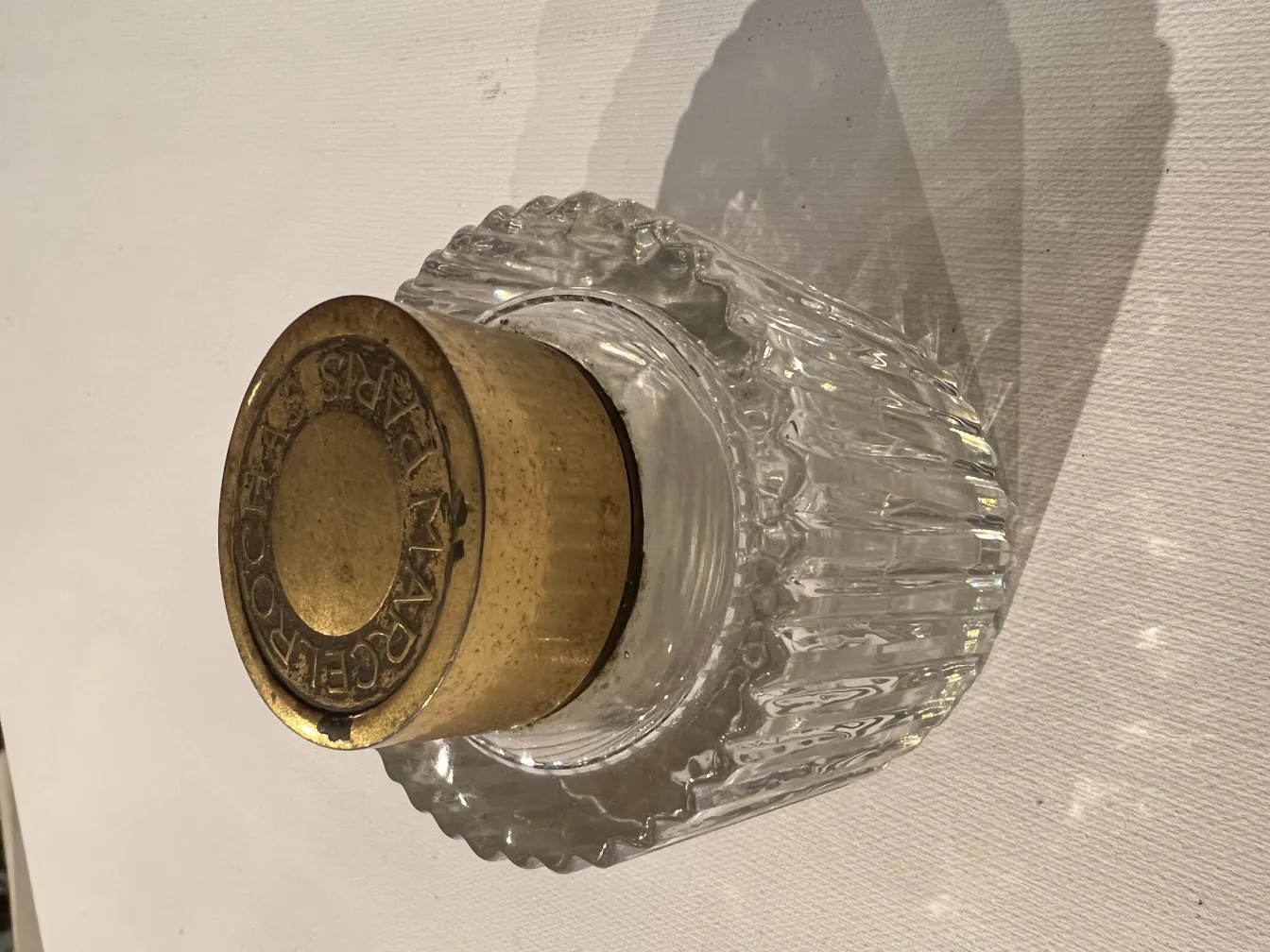 frasco de perfume antiguo con detalles en tapa dorada y forma ondulada