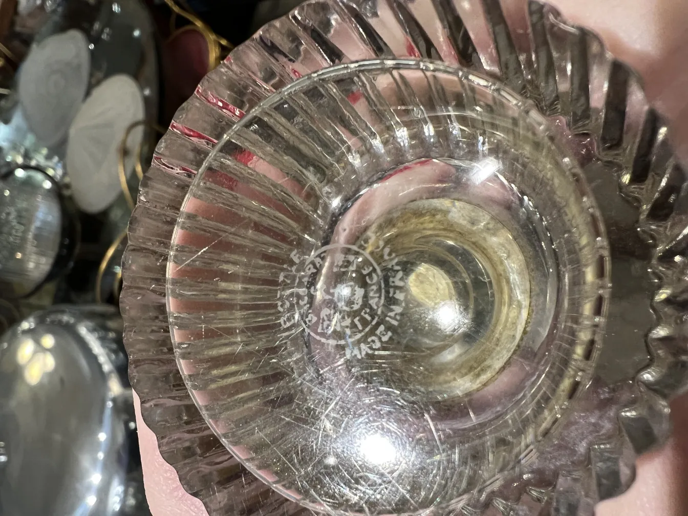 flacone di profumo antico con dettagli decorativi distintivi, circondato da oggetti antichi.