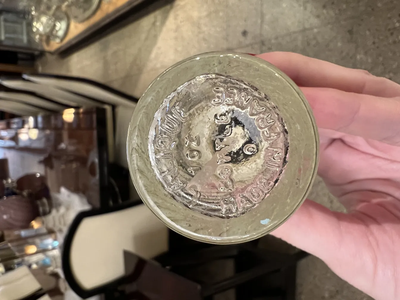 古董香水瓶，形状优雅，背景为经典家具，具有可见的细节。