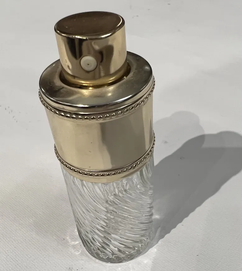 frasco de perfume antiguo con diseño ondulado y tapón dorado