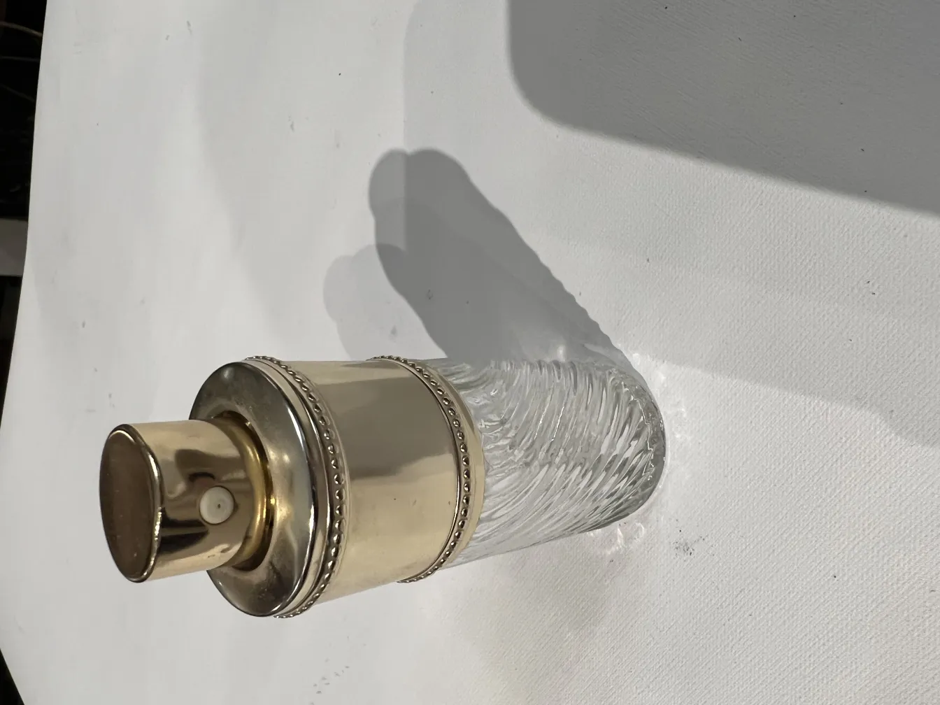 Flacon de parfum ancien avec un design élégant et un bouchon doré