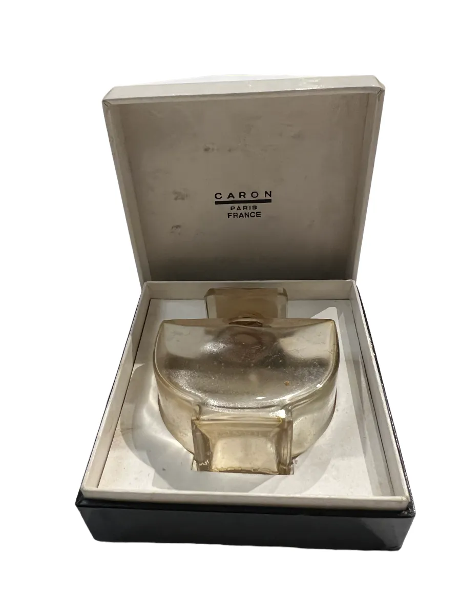 पुरानी इत्र की शीशी, जिसमें एक खूबसूरत ढक्कन है, एक बक्से में