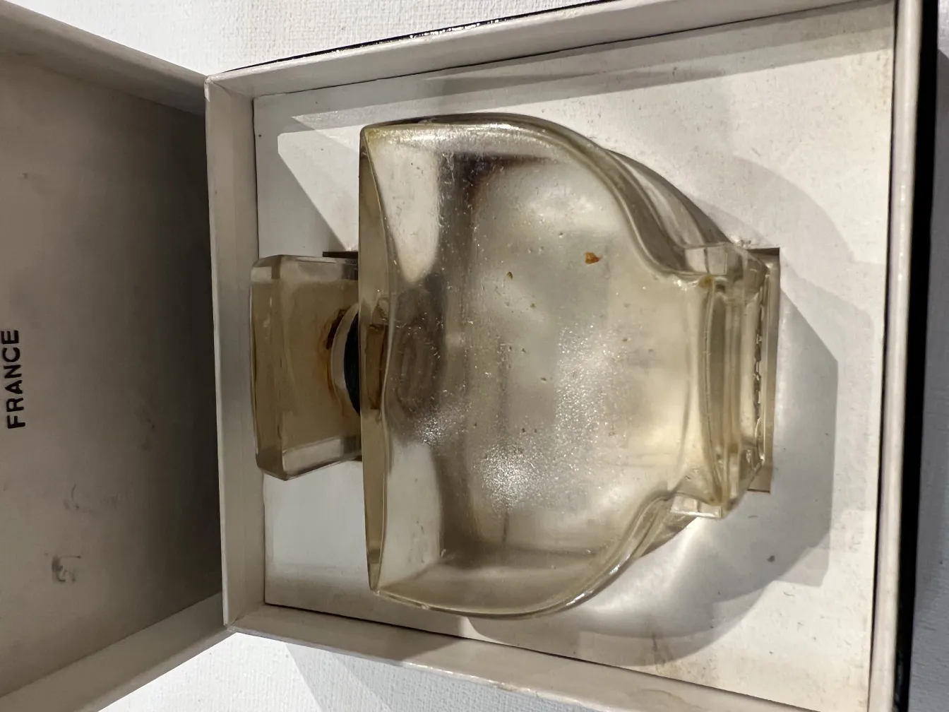 زجاجة عطر فرنسية قديمة داخل علبة، مع تصميم ناعم وأنيق.