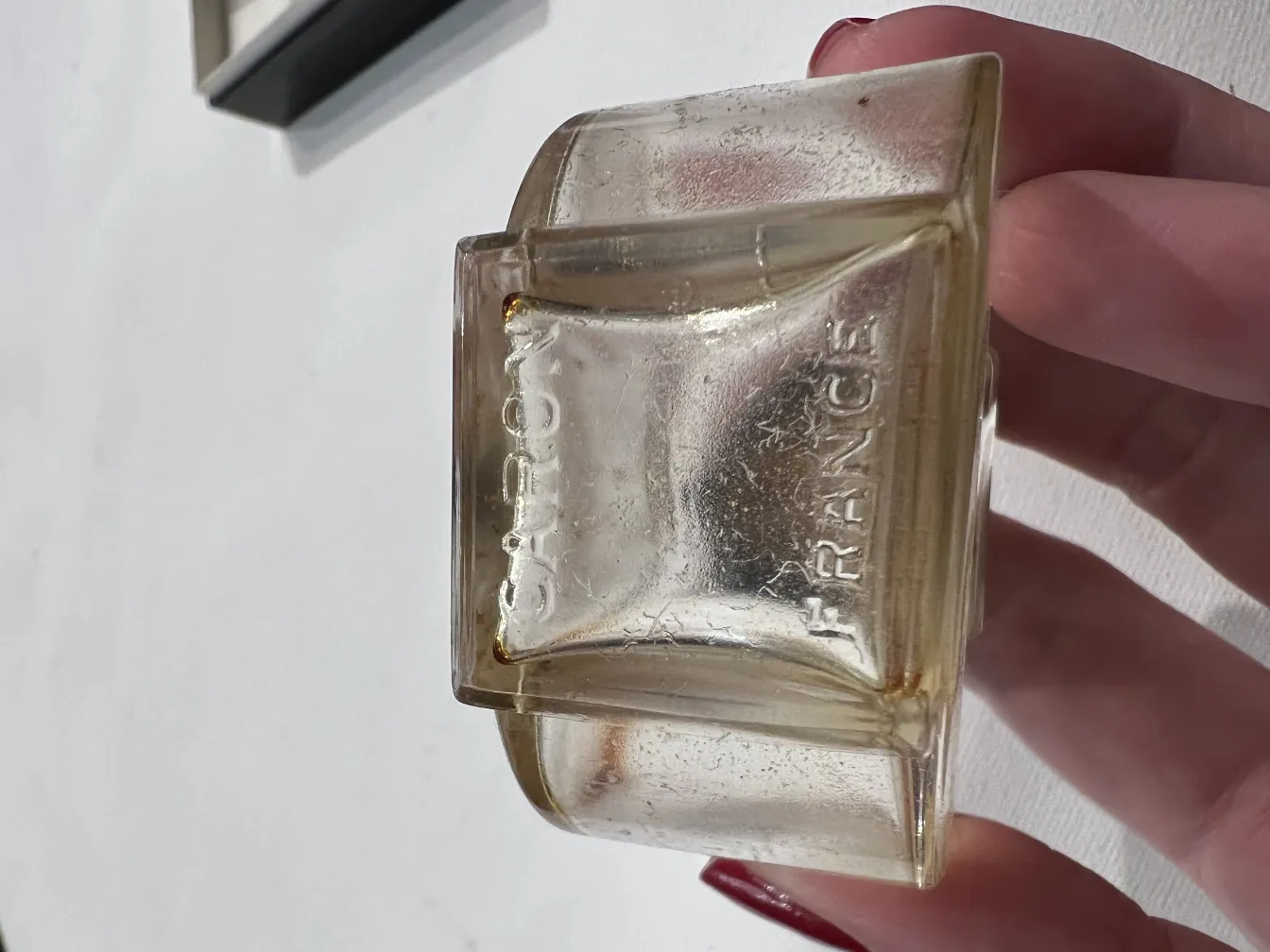 frasco de perfume antiguo de vidrio, forma única, ambiente neutro