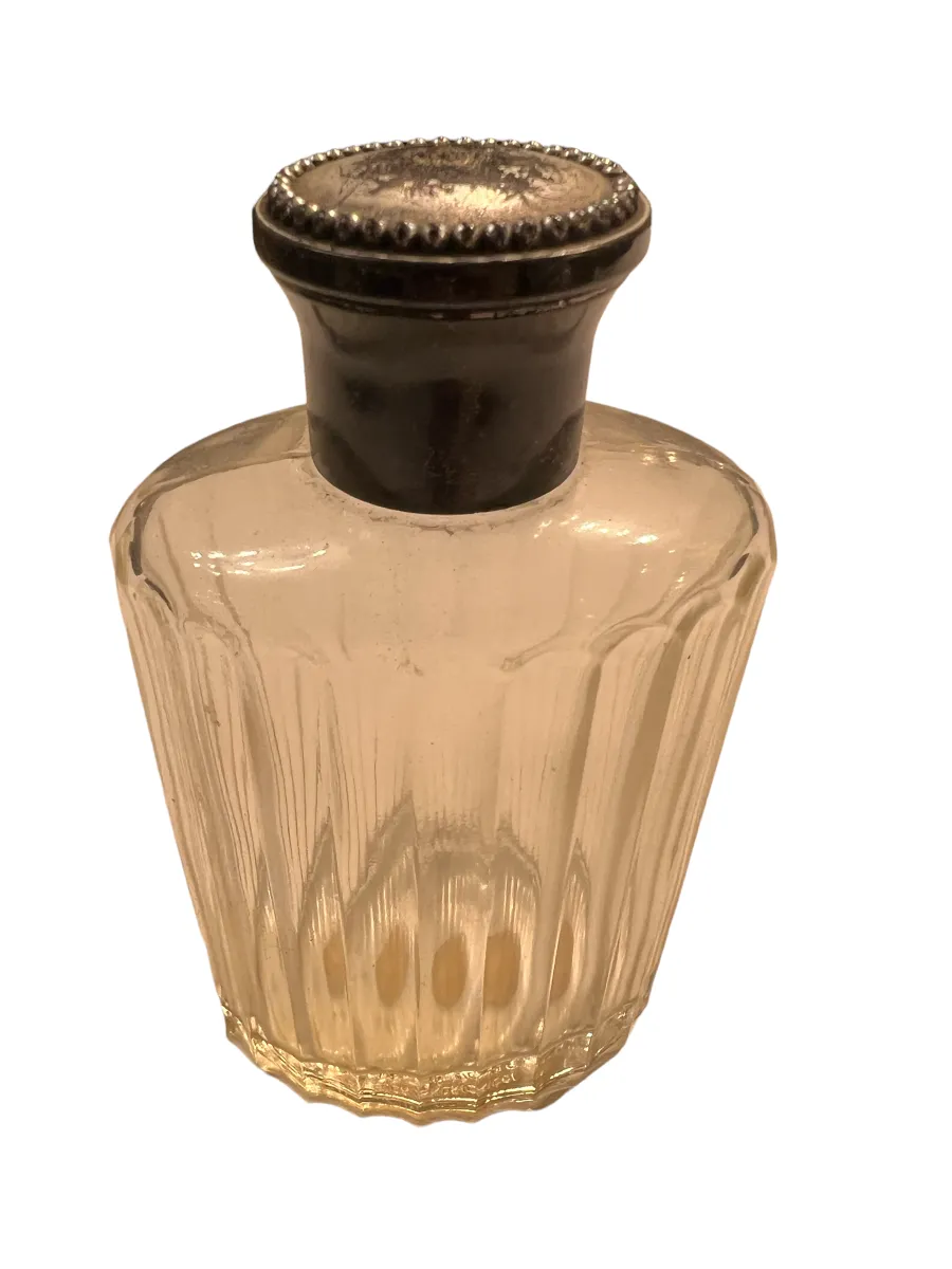antique perfume bottle with decorative metal cap, in neutral setting