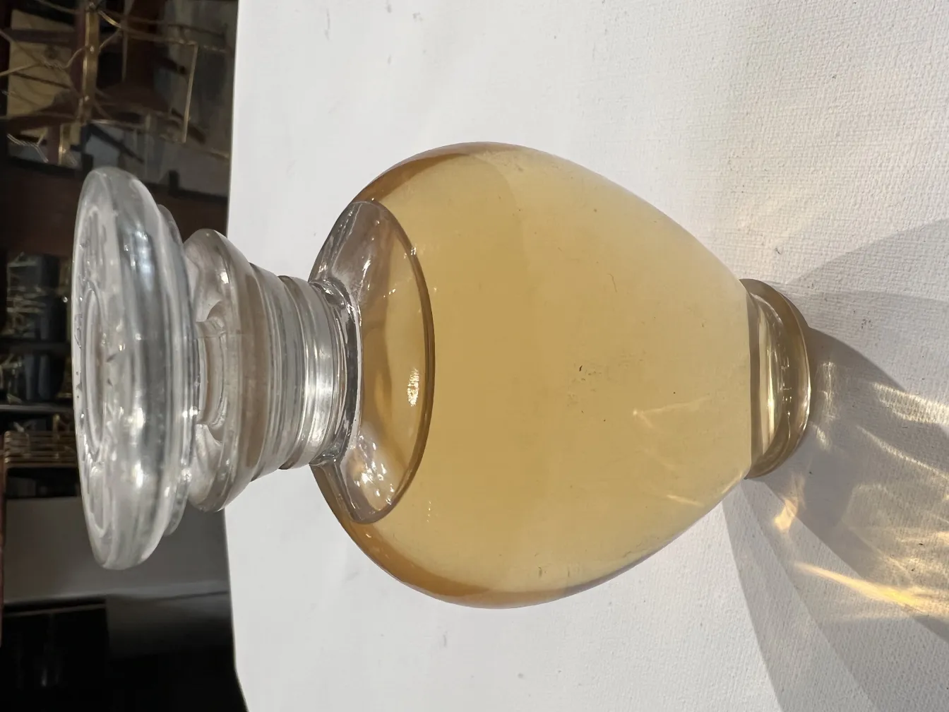 frasco antiguo de perfume con líquido amarillo claro y tapa