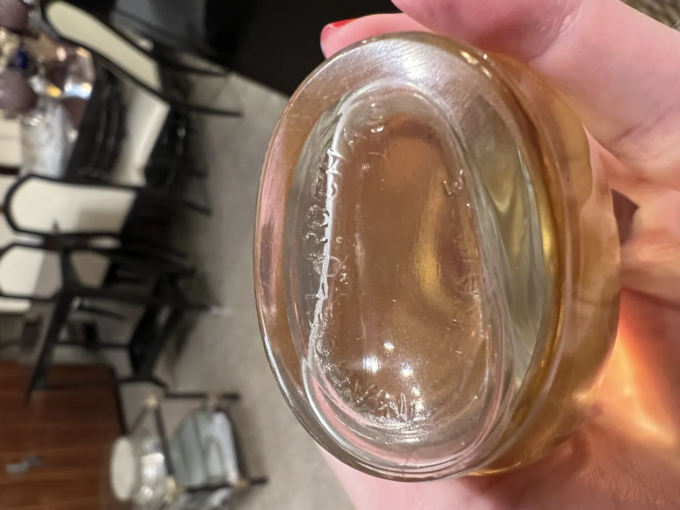 Flacone di profumo antico con forma ovale e tonalità dorata, in un contesto moderno