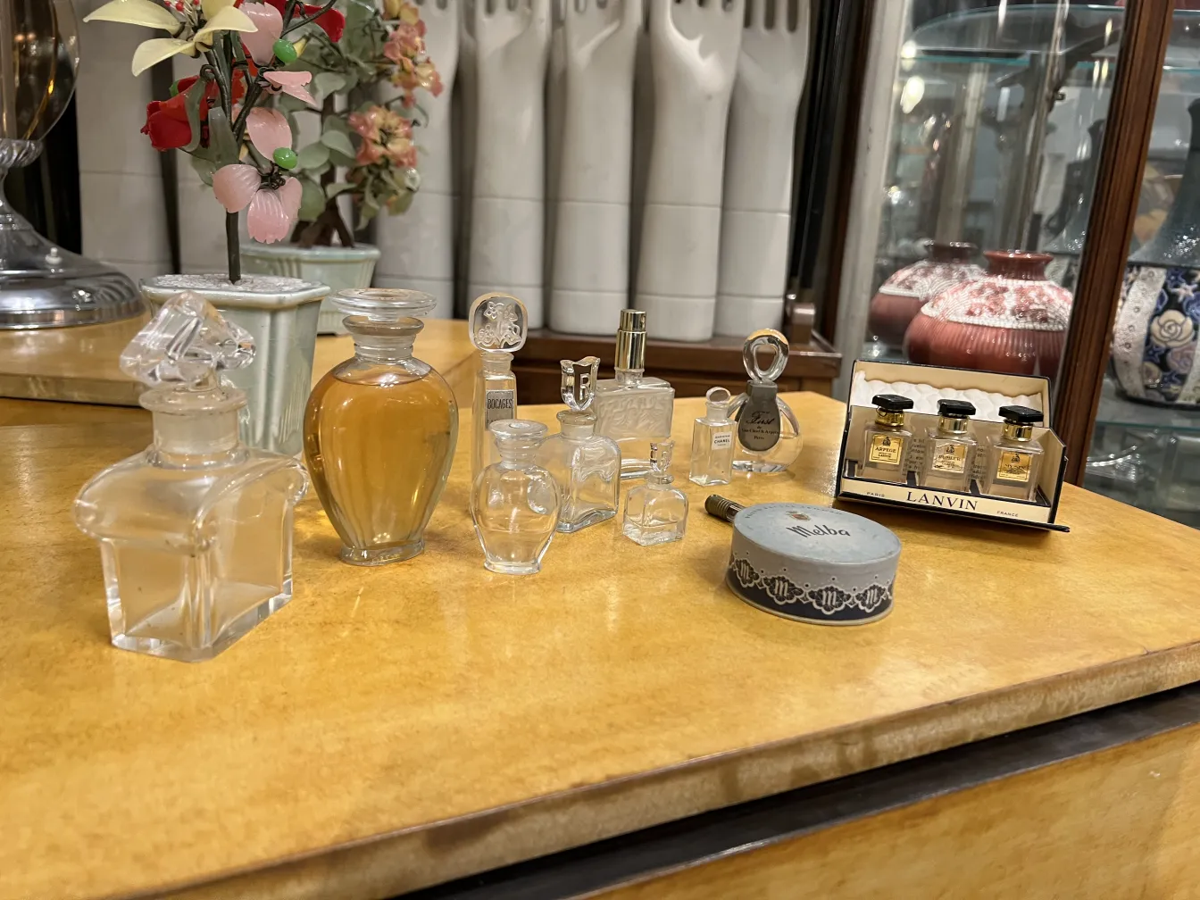 античный флакон для духов на столе с другими флаконами и цветами