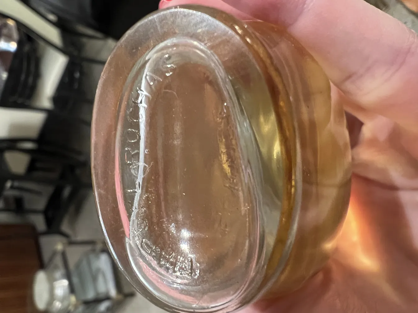 antike transparente Parfümflasche in der Hand mit einem schwachen Goldton