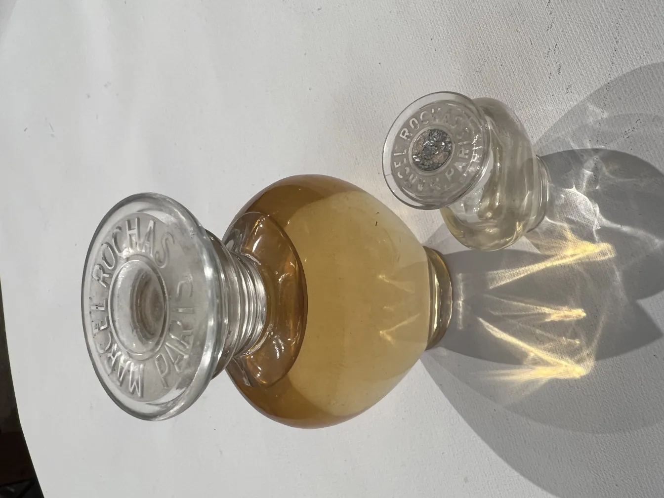 antique perfume bottle with decorative cap and golden liquid