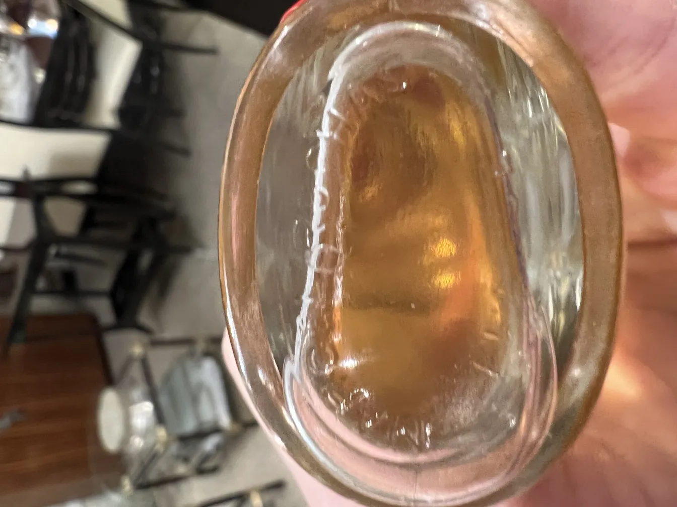 نظرة داخل زجاجة عطر قديمة مع سائل شفاف وتدرج ذهبي.