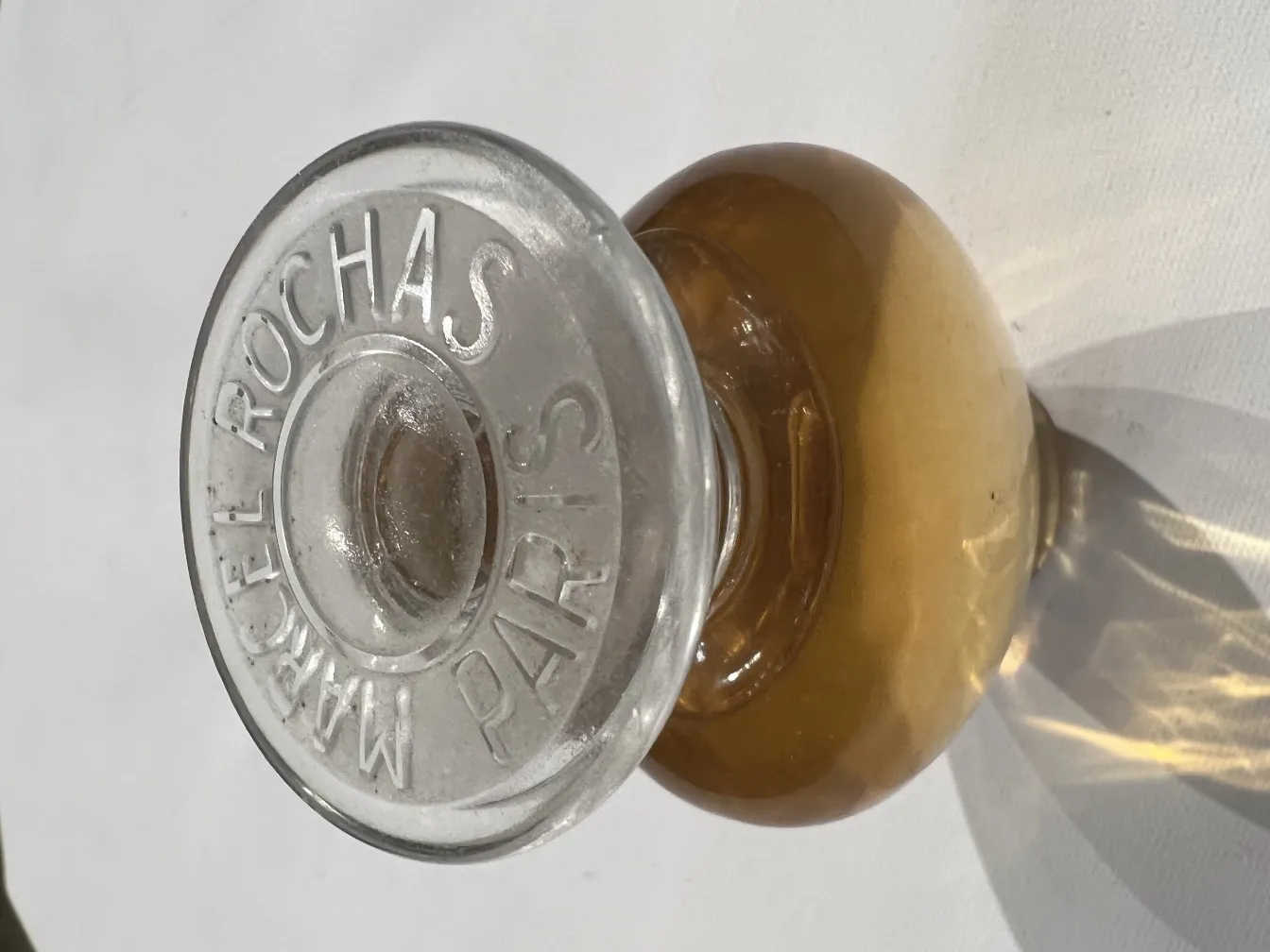 frasco de perfume antiguo con tapa transparente y marca