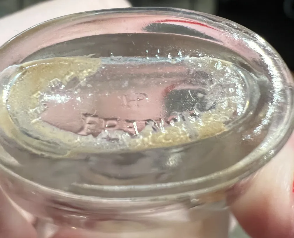 زجاجة عطر قديمة بتصميم أنيق، تفاصيل مرئية في الأسفل.