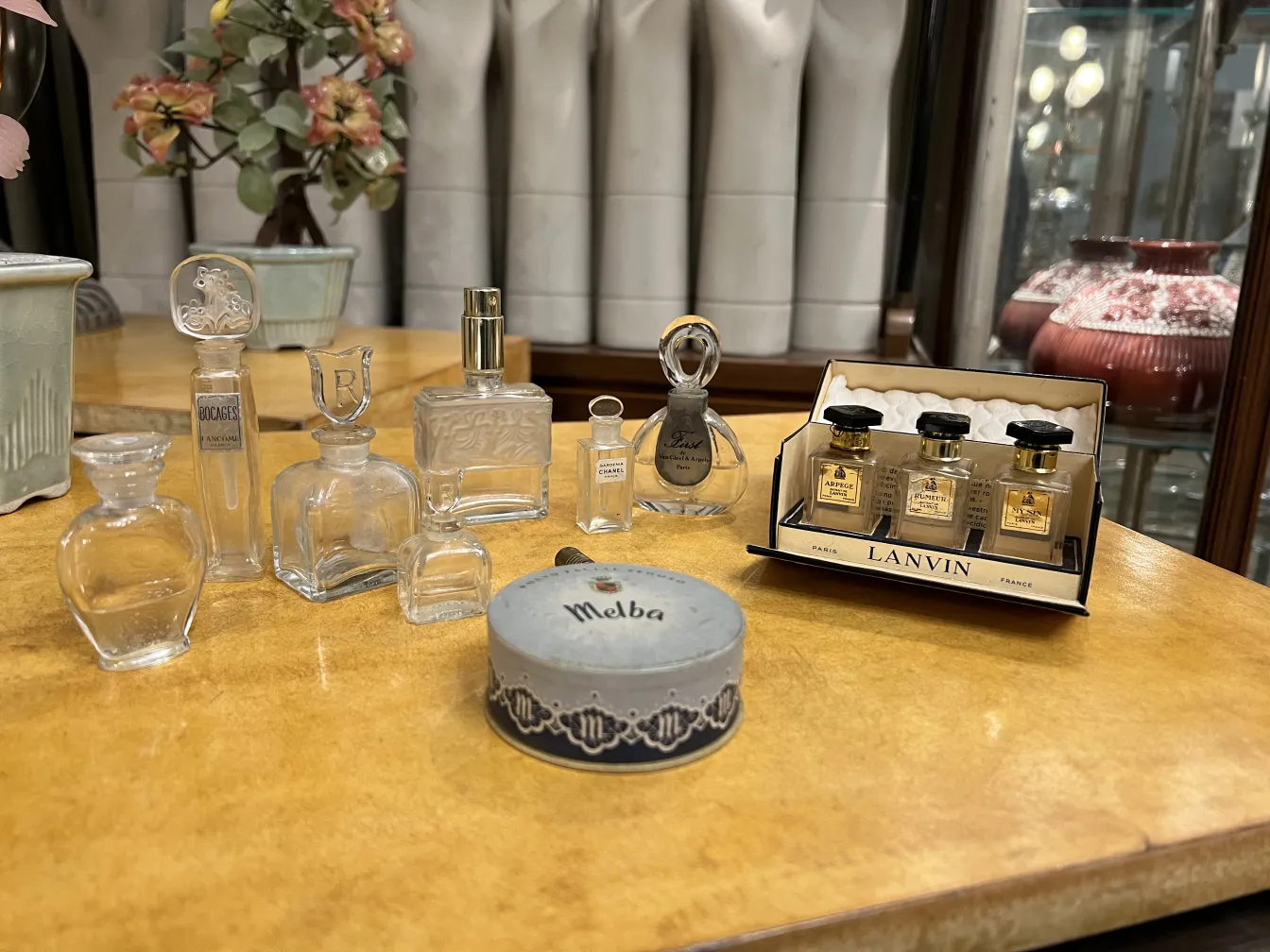 flacone di profumo antico, circondato da vari flaconi in un ambiente elegante