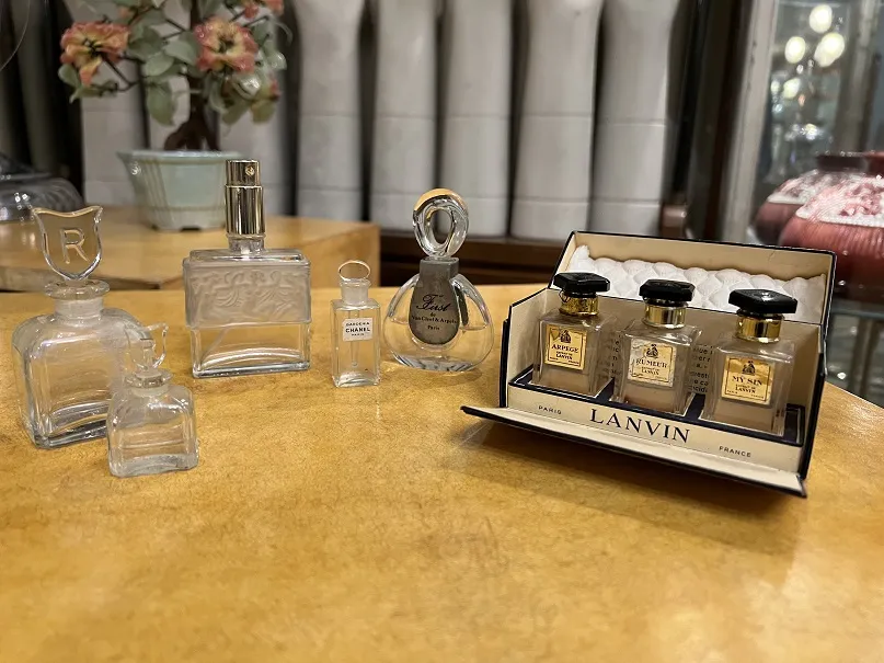 various antique perfume bottles on a wooden table