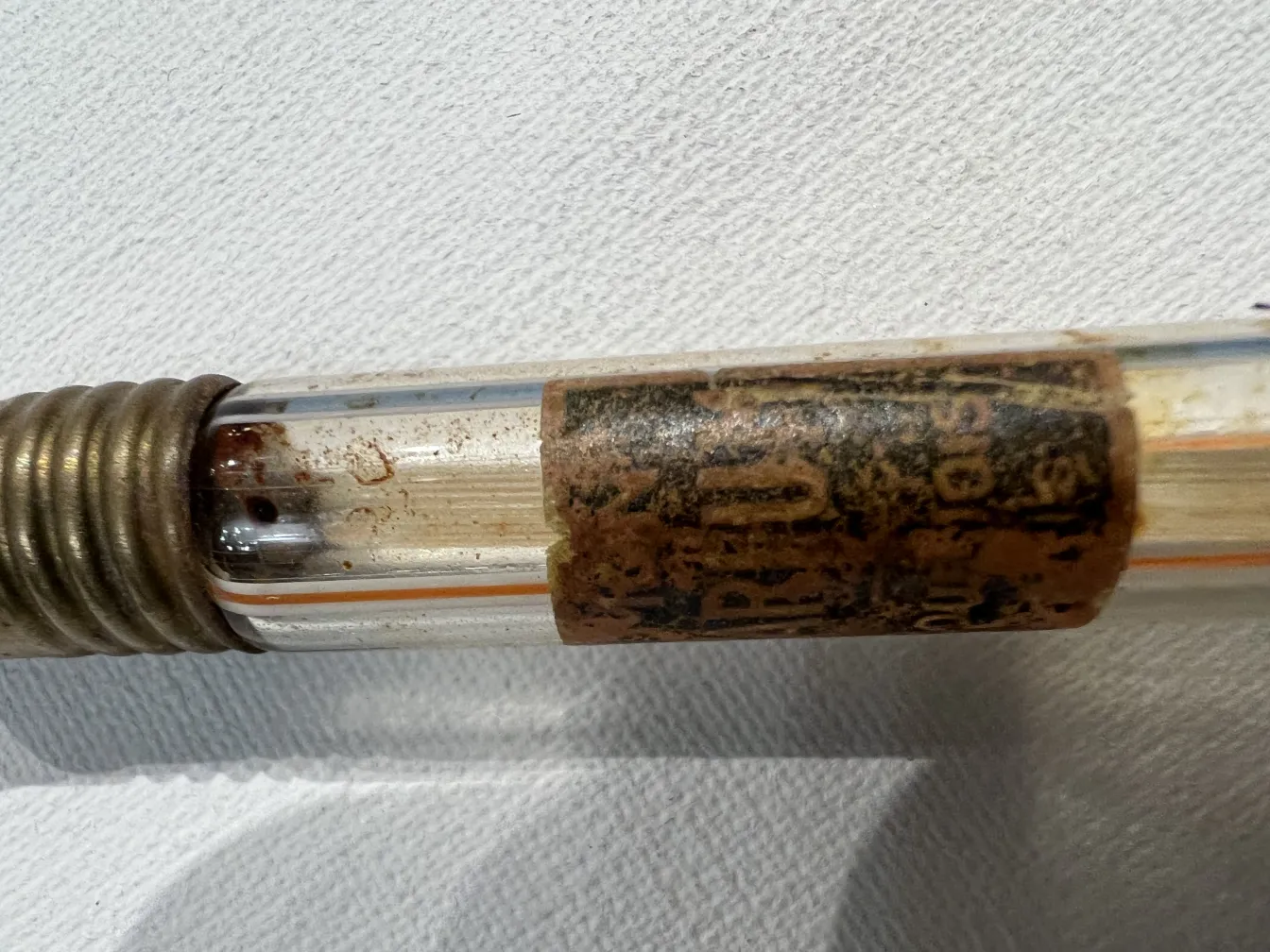 flacone di profumo antico con etichetta usurata, mostra parte metallica.