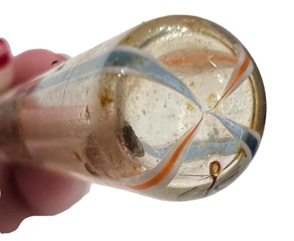 Flacon de parfum ancien avec forme décorative et couleurs vives, dans un fond doux.