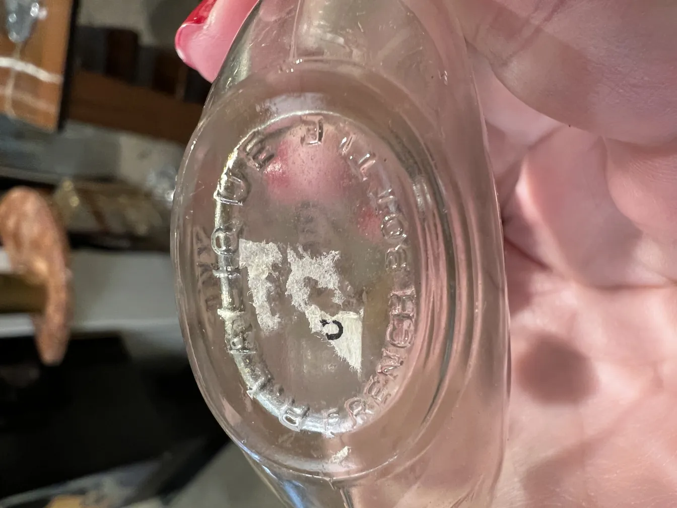 antique perfume bottle in hand with visible inscription