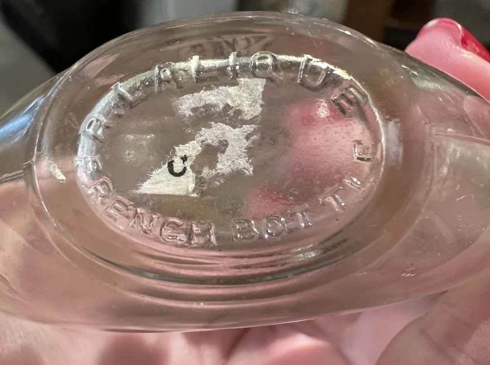 Flacon de parfum ancien avec des caractéristiques classiques.