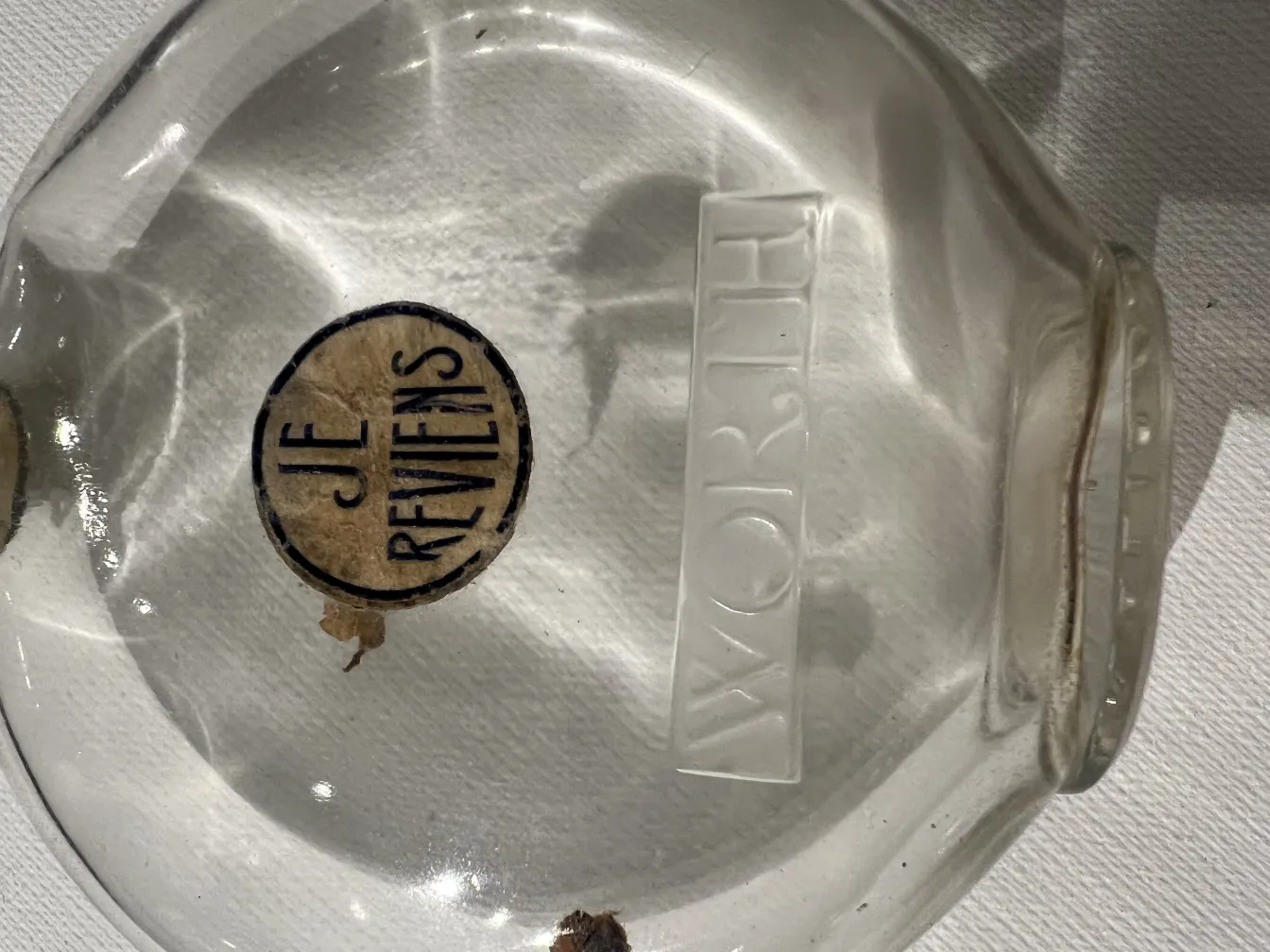 frasco de perfume antigo com etiqueta je reviens, estilo clássico, decorativo, transparente