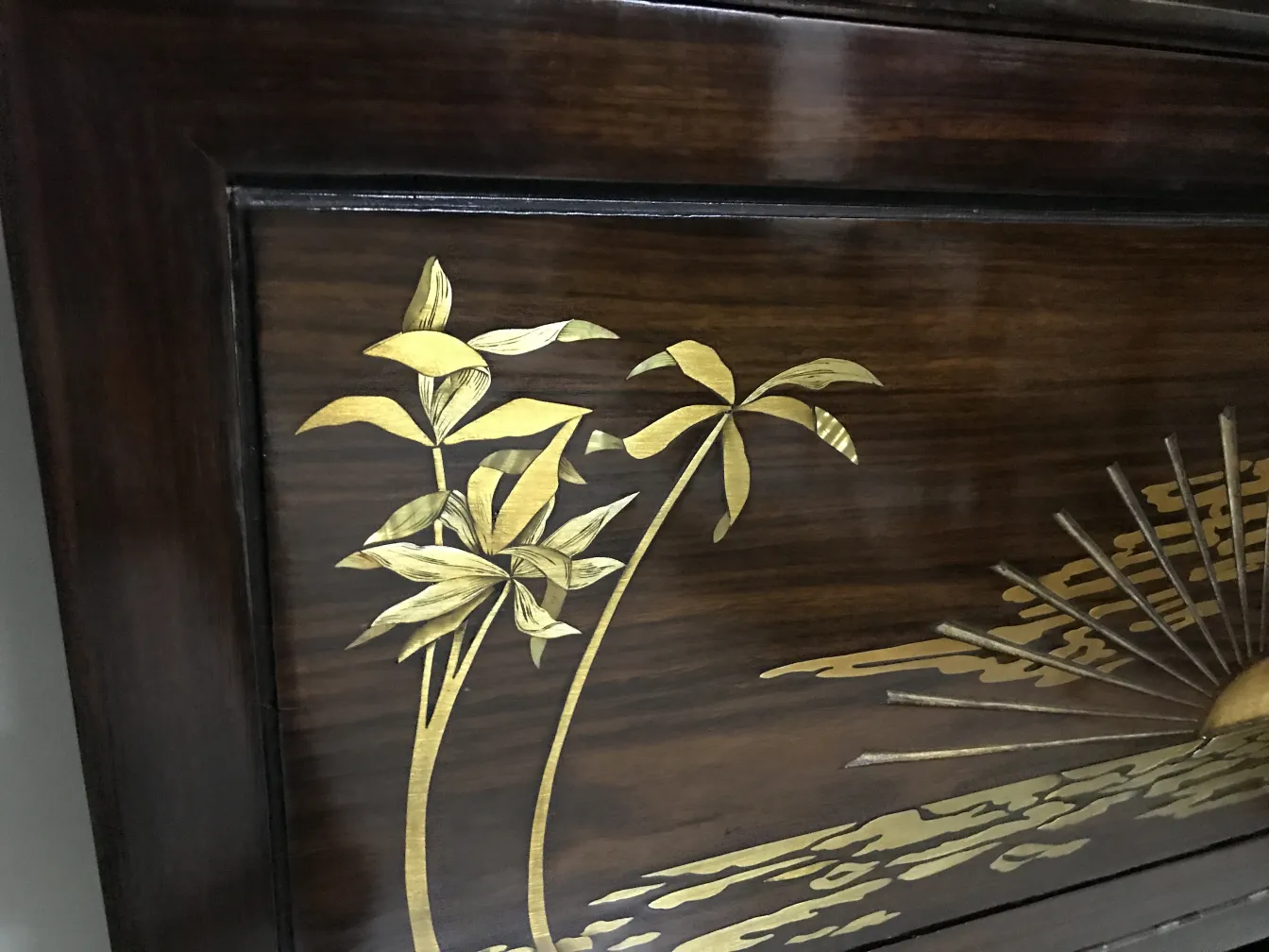 vitrine ancienne carlo zen décorée de feuilles dorées sur fond sombre