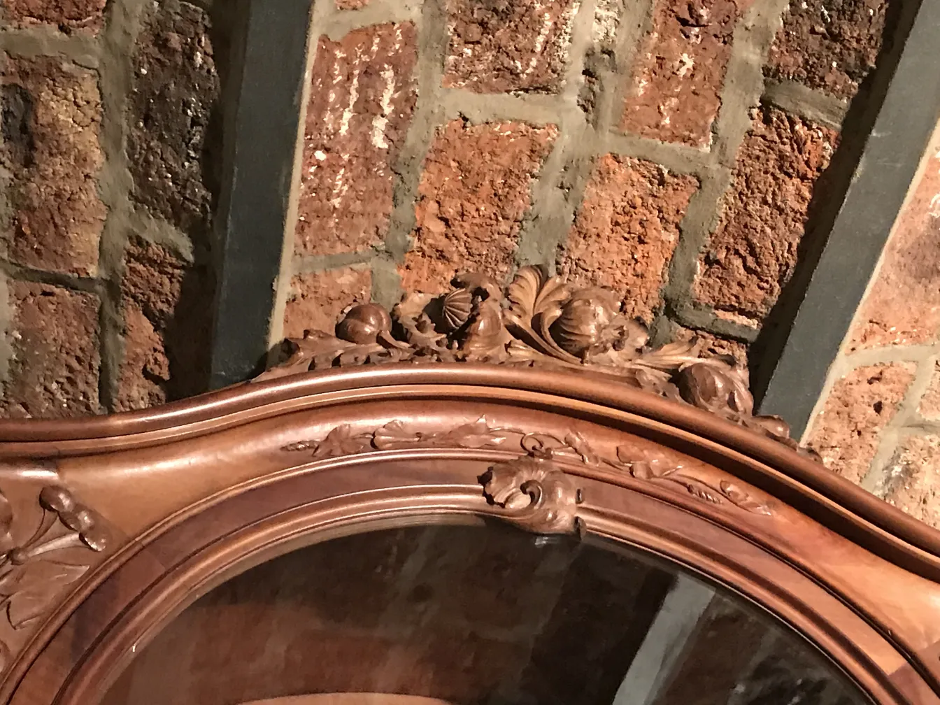 Dettagli ornamentali della vetrina antica E.Dienst - Paris su sfondo in mattoni