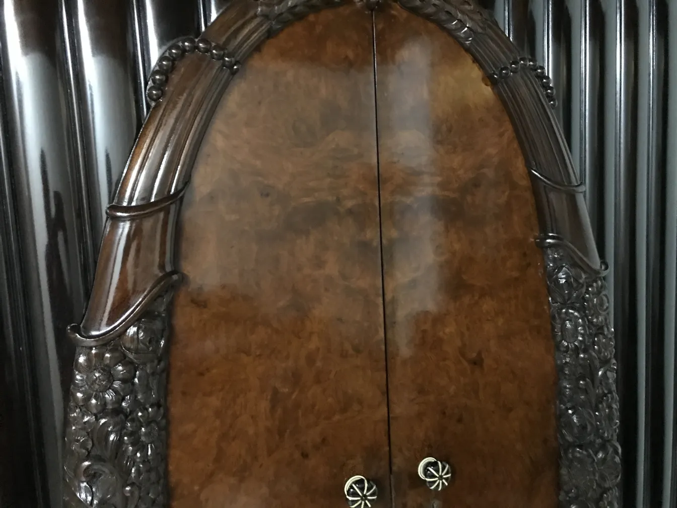 Vitrina antigua con puerta decorada y detalles grabados.