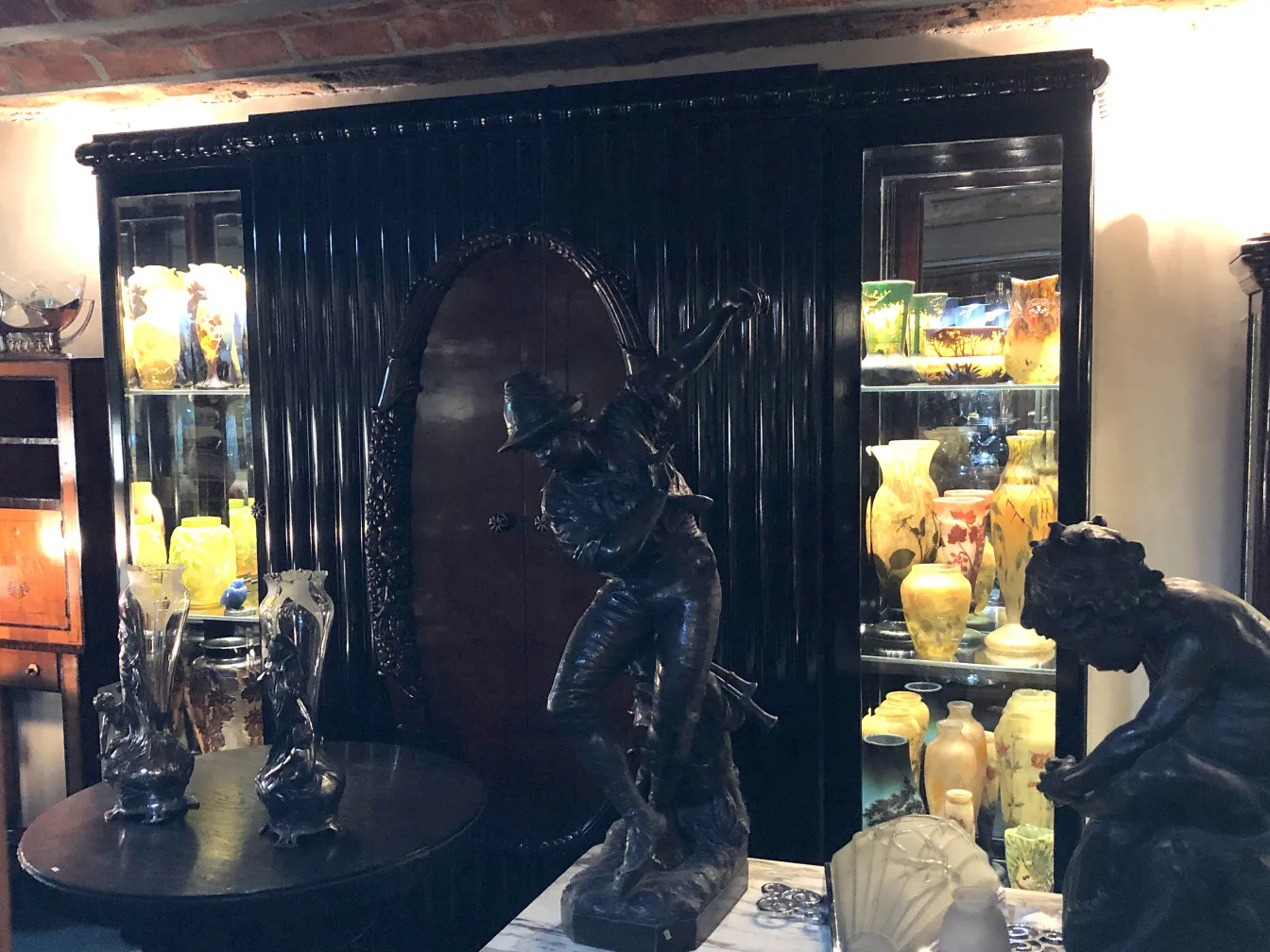 antike vitrine in einem dekorativen setting mit bunten skulpturen und vazen