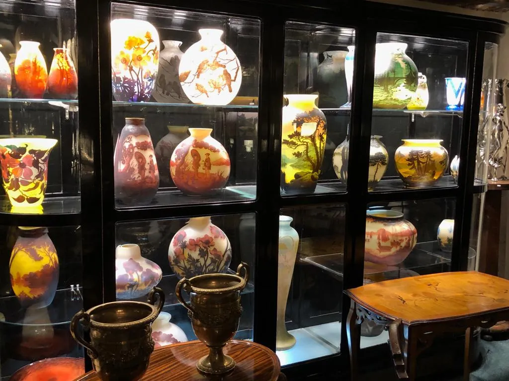 vitrine antiga com vasos coloridos e itens de coleção