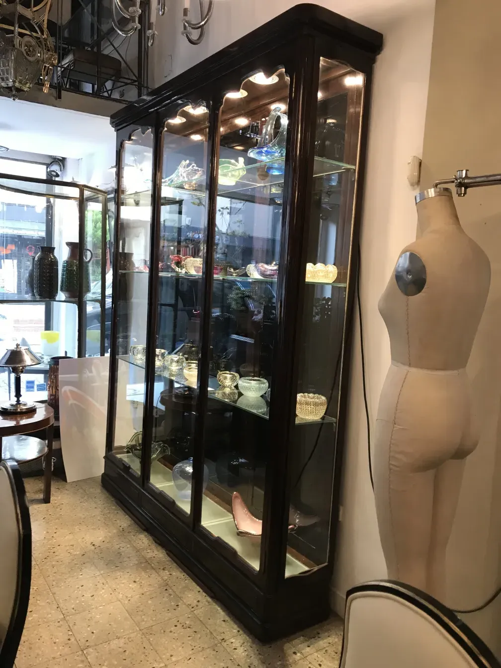 vitrina antigua con luces y objetos decorativos en su interior