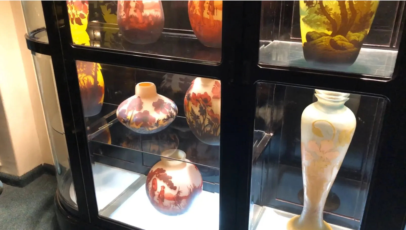 Vitrine exposant divers vases décoratifs.