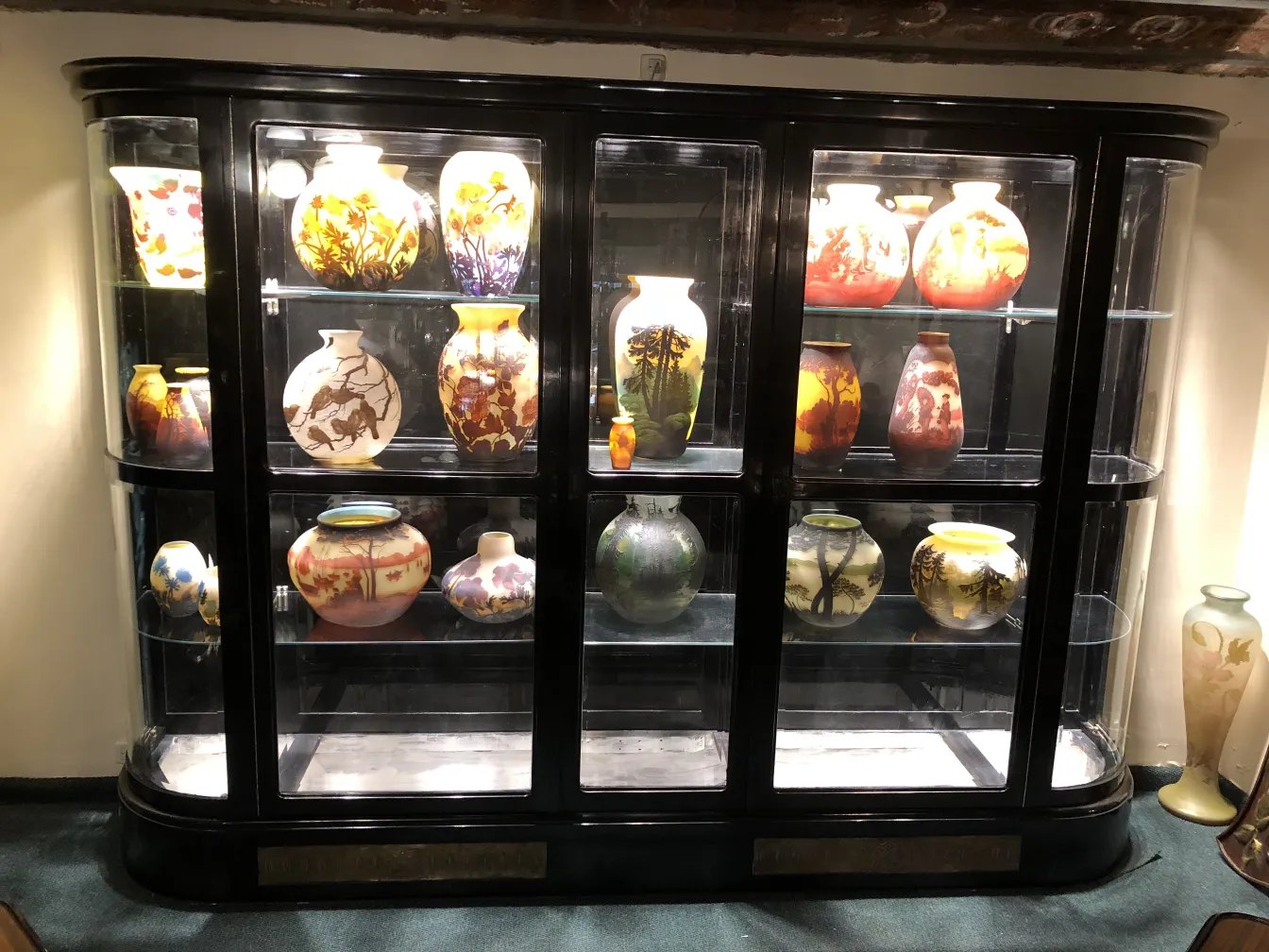 古い陳列ケースに様々な装飾的な花瓶が展示されています