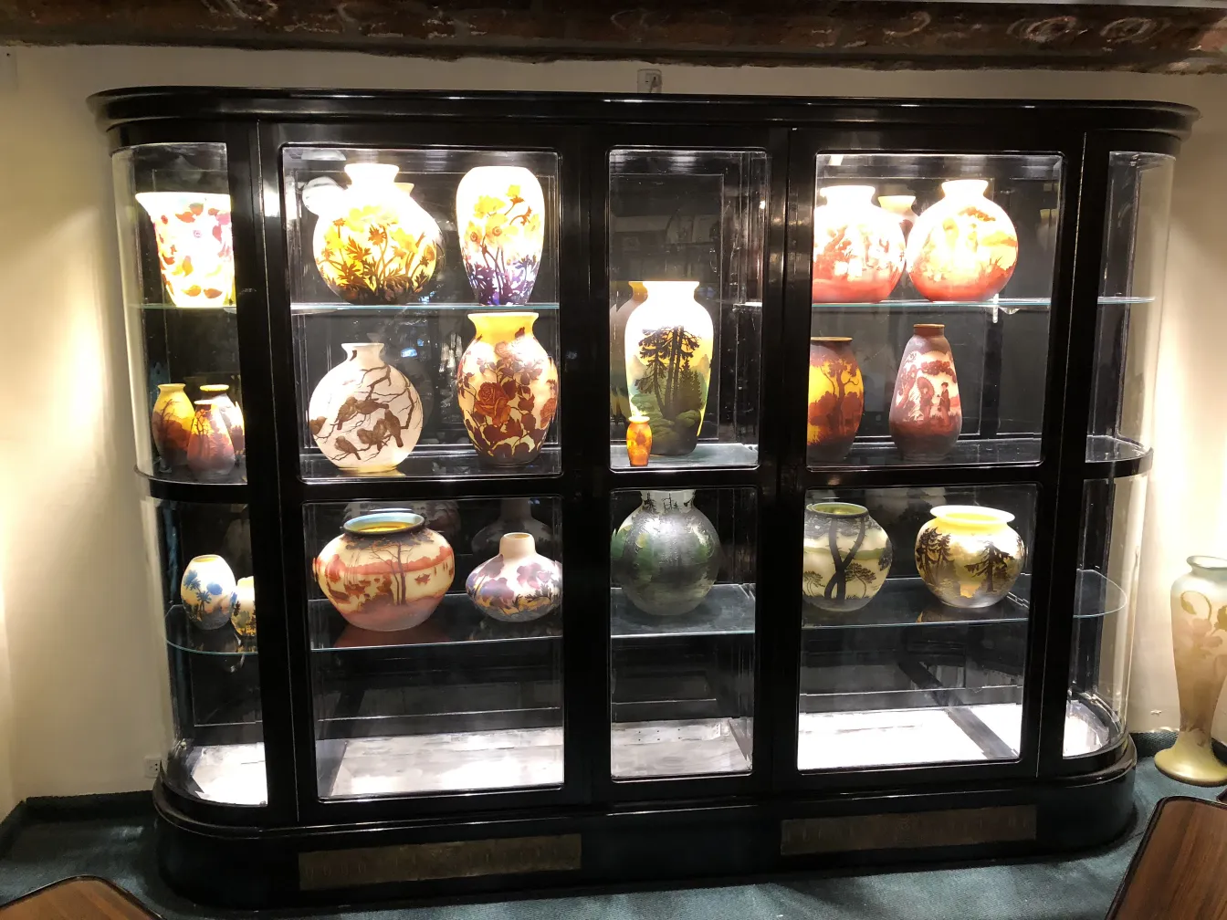 antique display cabinet showcasing various decorative vases