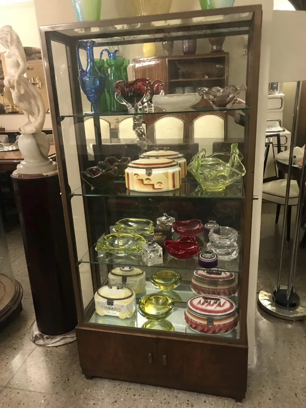 vitrine antique avec plusieurs étagères et objets décoratifs