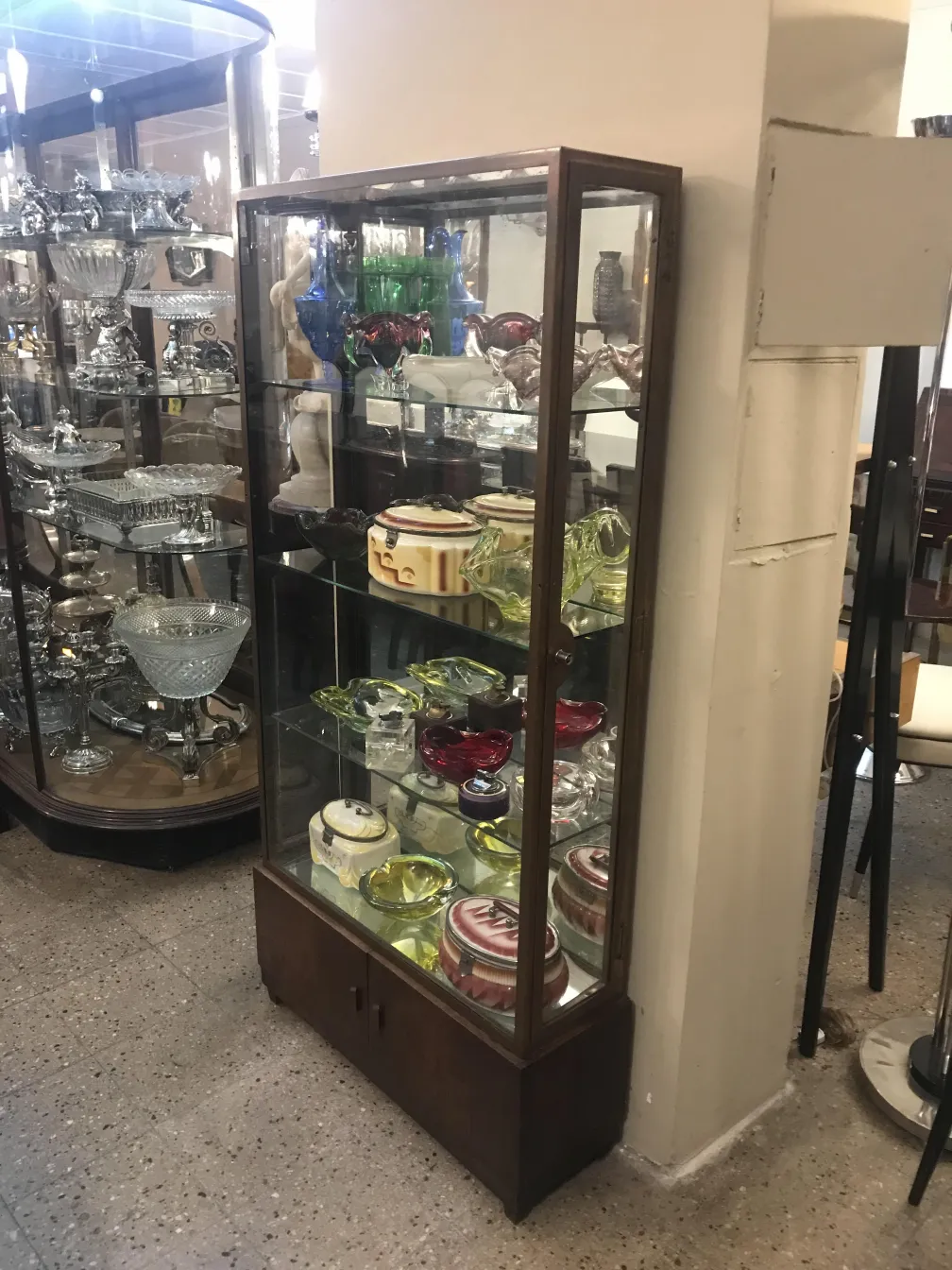 Vitrina antigua con colecciones coloridas y vidrieras.