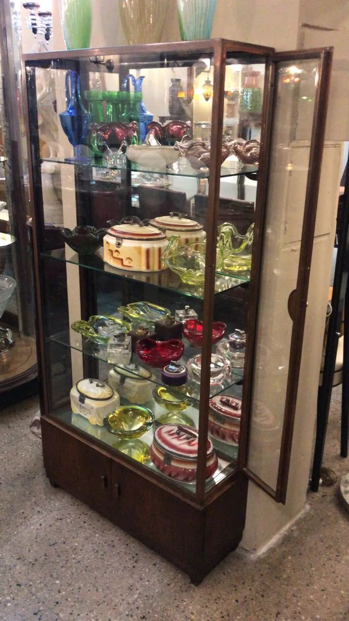 Antike Vitrine, die verschiedene Sammlerstücke in lebhaften Farben präsentiert.