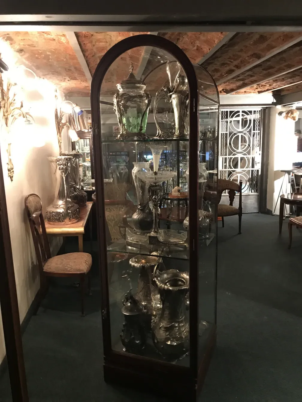 Antike Vitrine mit verschiedenen Ausstellungsgegenständen im Inneren, Hintergrundbeleuchtung.