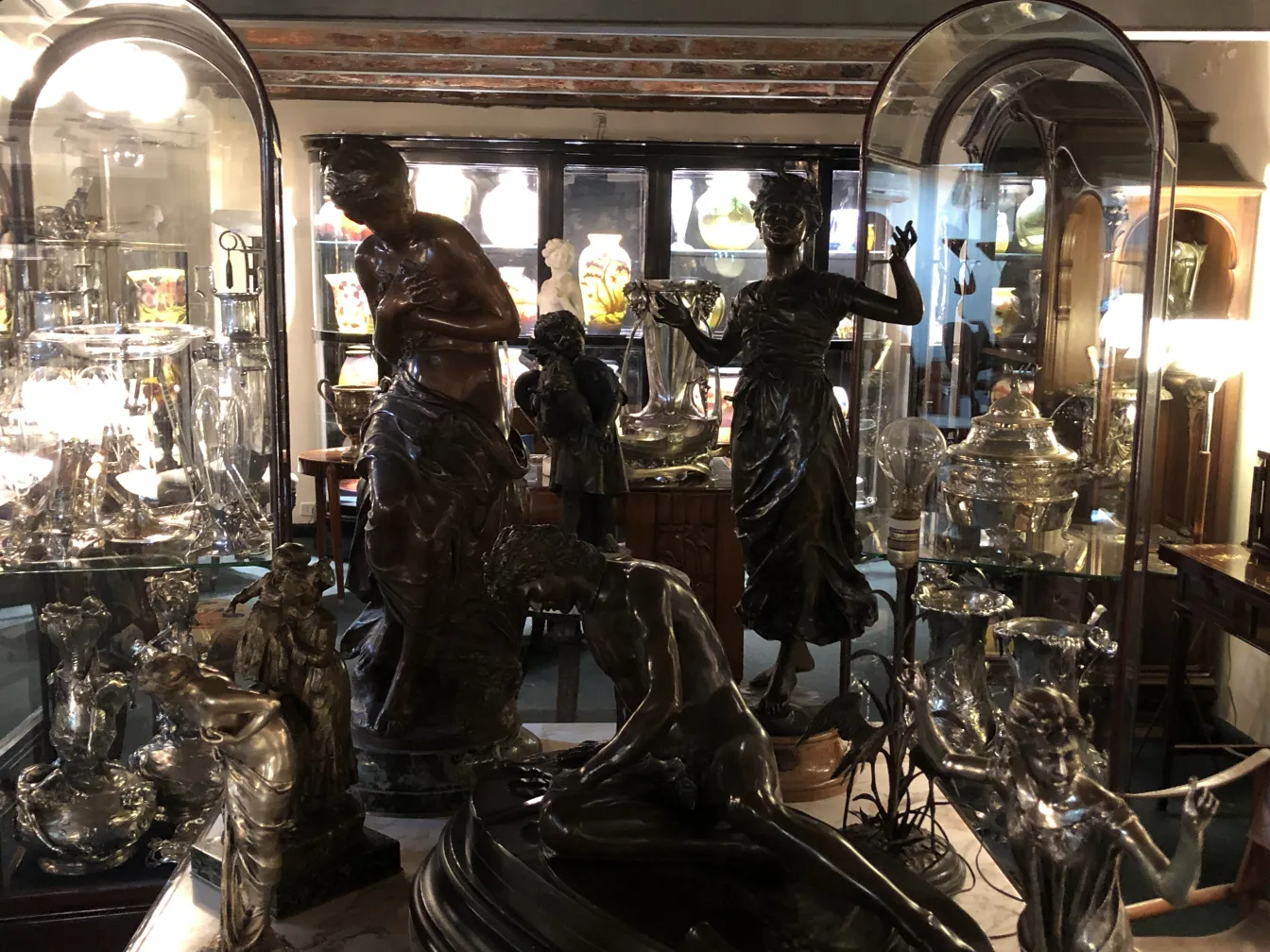 Antike Vitrine mit Skulpturen und beleuchtetem Dekor, elegantes Ambiente