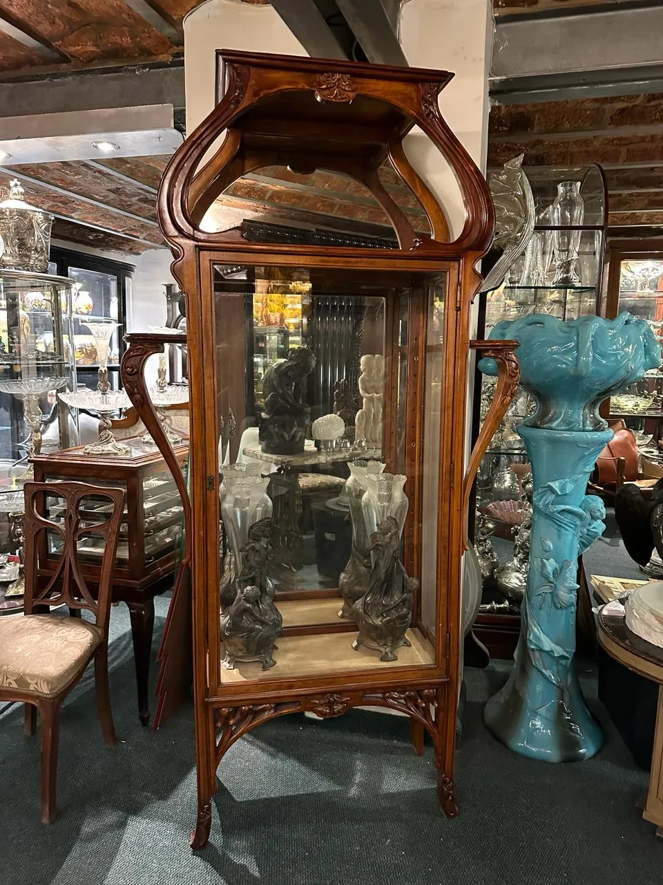 antique display cabinet with intricate details and decorative figures, elegant atmosphere
