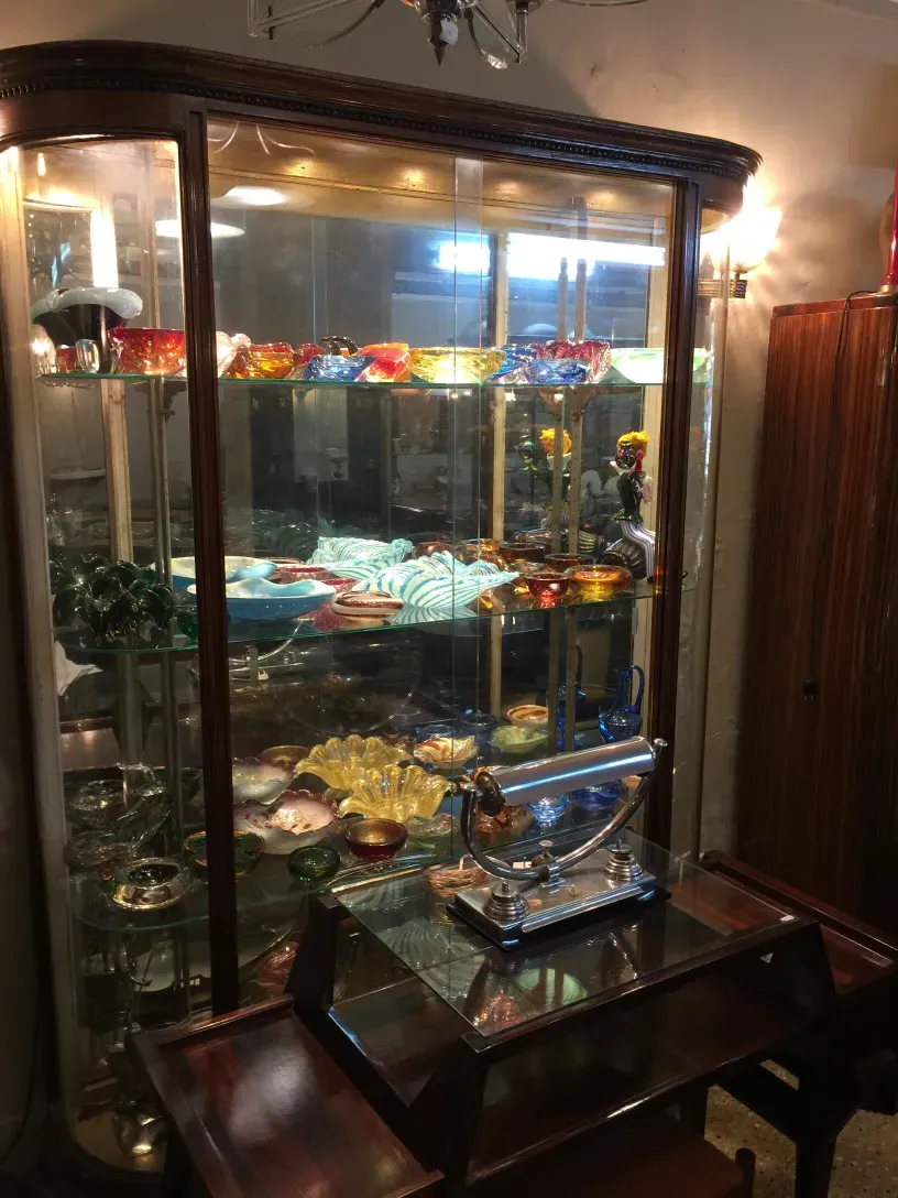 古董展示柜，带有照明和色彩丰富的装饰物品。