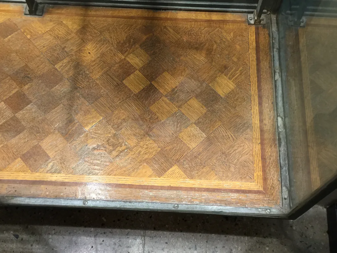 Vitrina antigua con un piso de diseño en dos tonos, mostrando un ambiente de antigüedad.