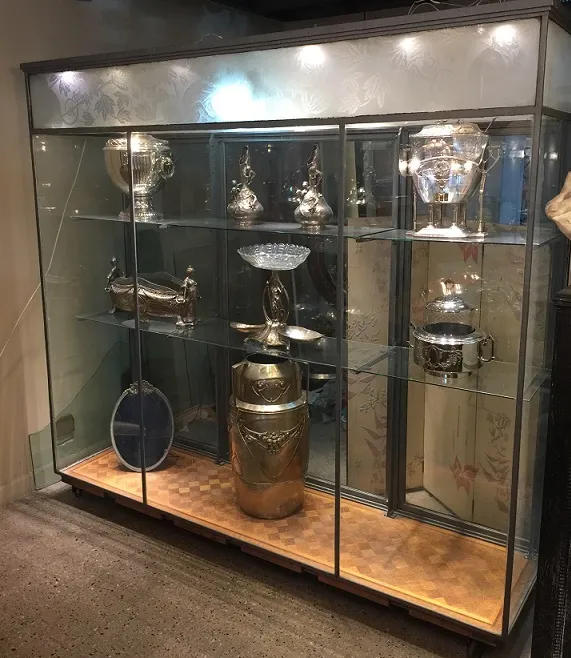 vitrina de antigüedades con trofeos y objetos decorativos