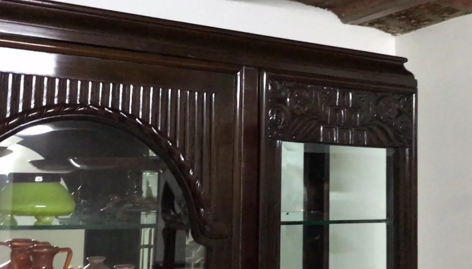 Vetrina antica con dettagli intricati e forma elegante in un ambiente decorativo.