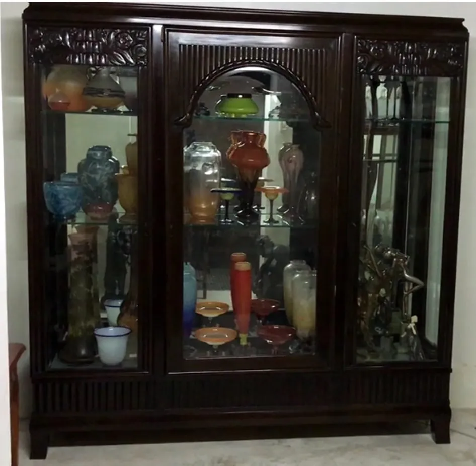 Antique display cabinet showcasing colorful dishware and decor