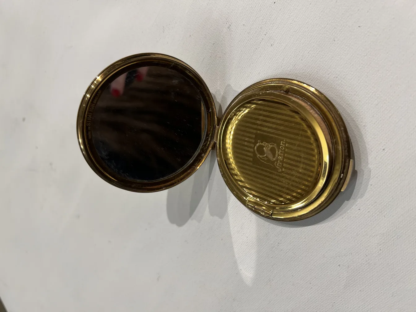 compacto antiquado em tons de dourado com espelho