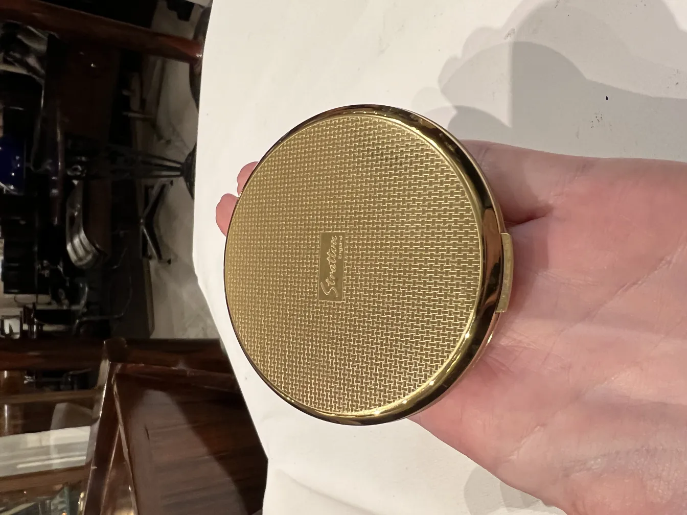 antike goldene Kompakt mit eleganter Textur in der Hand