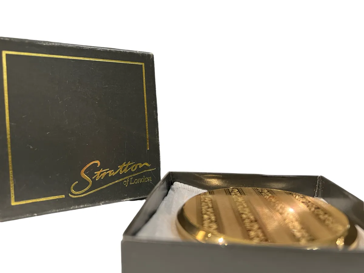 Antique golden compact with striped design, elegant